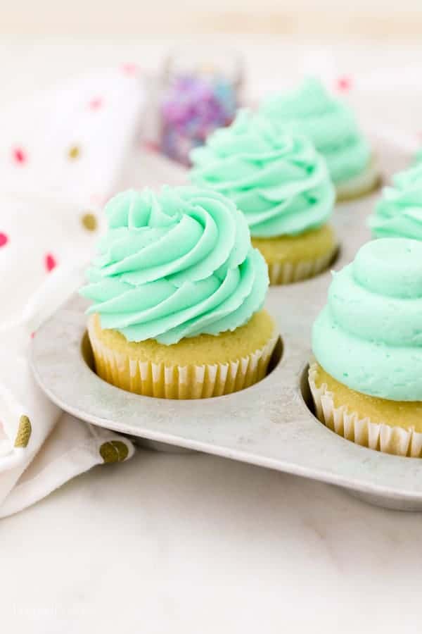 A vintage baking tray filled with beautifully decorated cupcakes