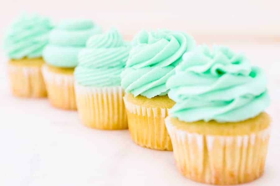Cupcakes lined up in a row to show the different types of piping tips you can use to decorate cupcakes