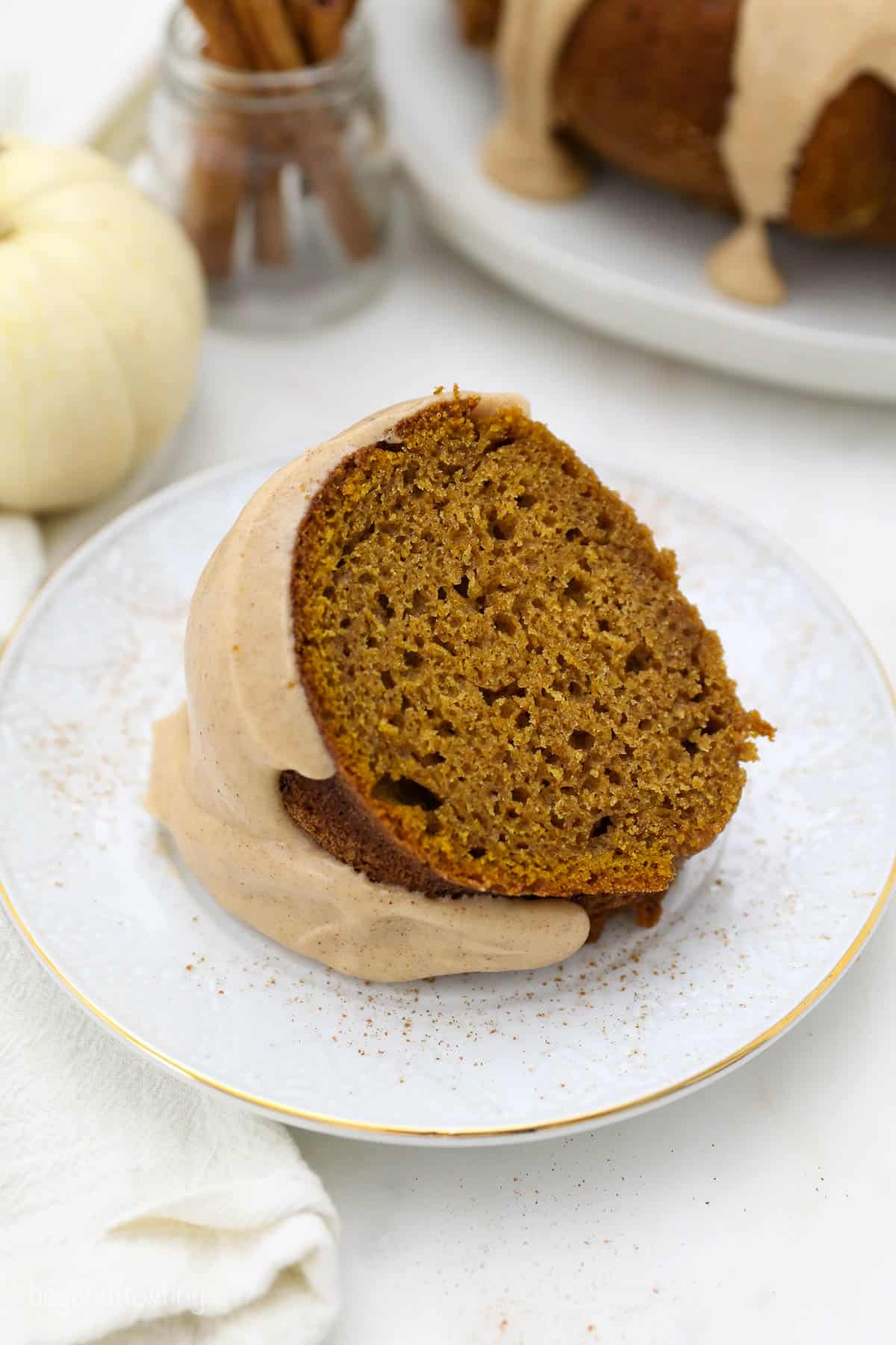 An overhead shot of a slice of pumpkin cake with a brown butter glaze