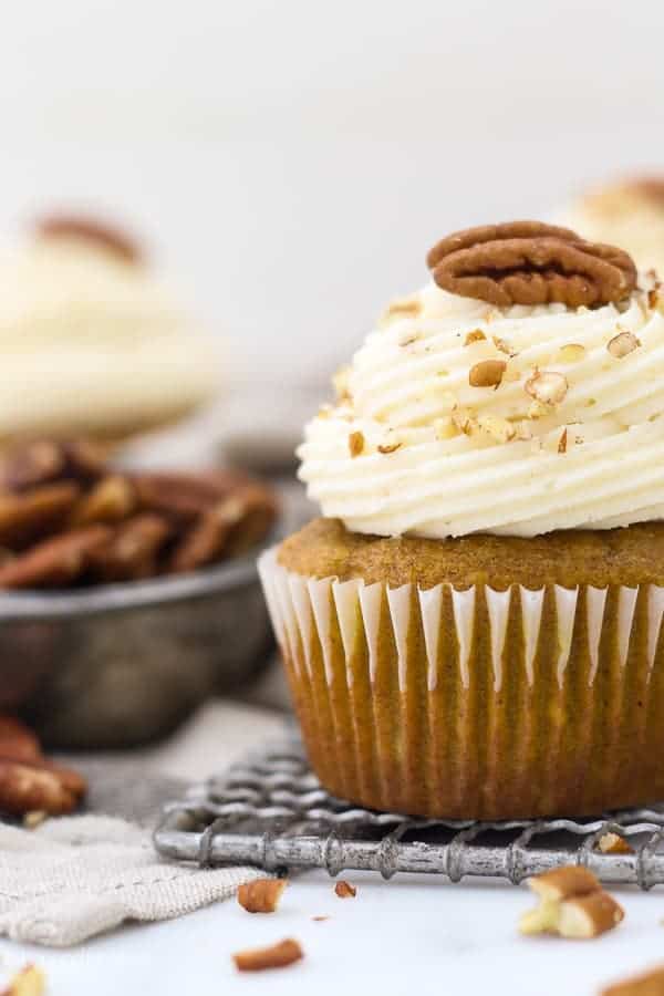A super close up shot of a gorgeous frosting swirl garnished with crushed pecans.
