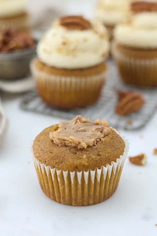 A pumpkin cupcake with the center removed showing the pecan pie filling.