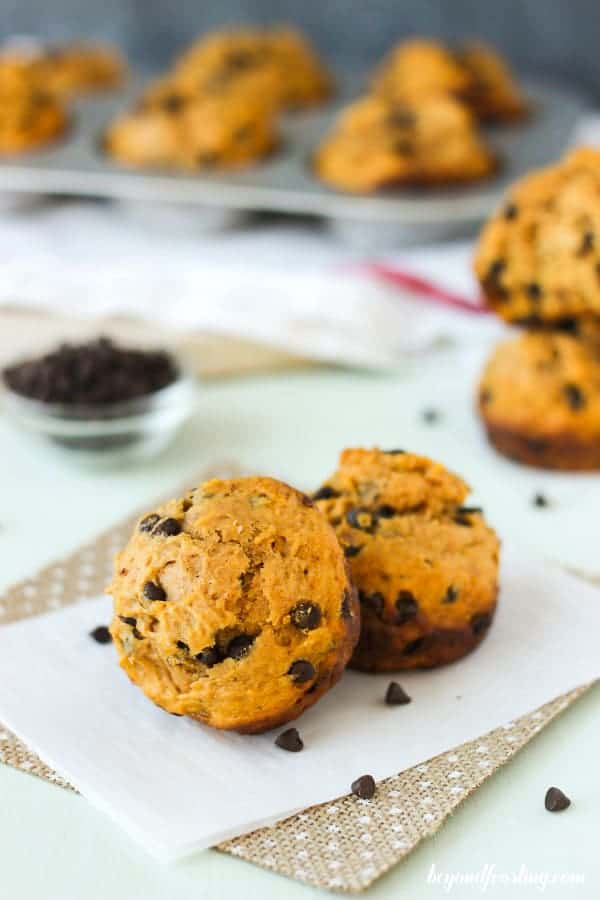 Two sweet potato muffins sitting on burlap and parchment paper