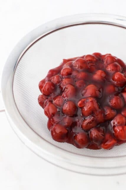 Cherry pie filling in a strainer