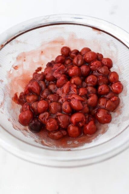 cherry pie filling in a strainer