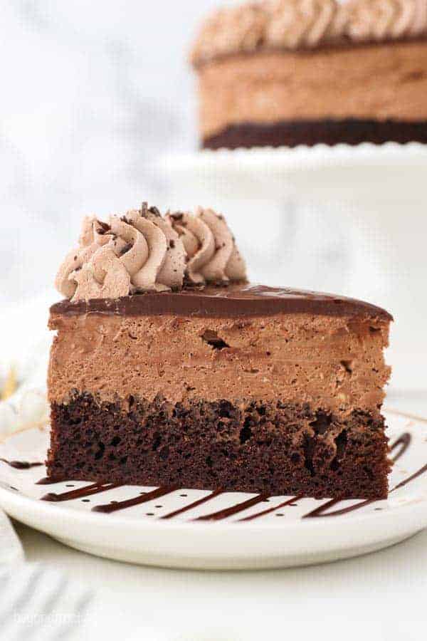 A close up shot showing the layers of the chocolate mousse cake. A layer of chocolate cake and a thick chocolate mousse is covered with ganahce.