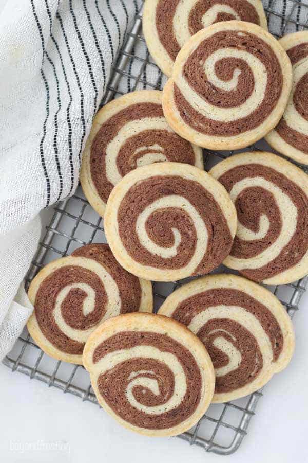 An overhead shot of vanilla and chocolate pinwheel cookies on a vintage wire baking rack.