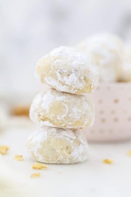 A stack of 3 Snowball Cookies rolled in powdered sugar