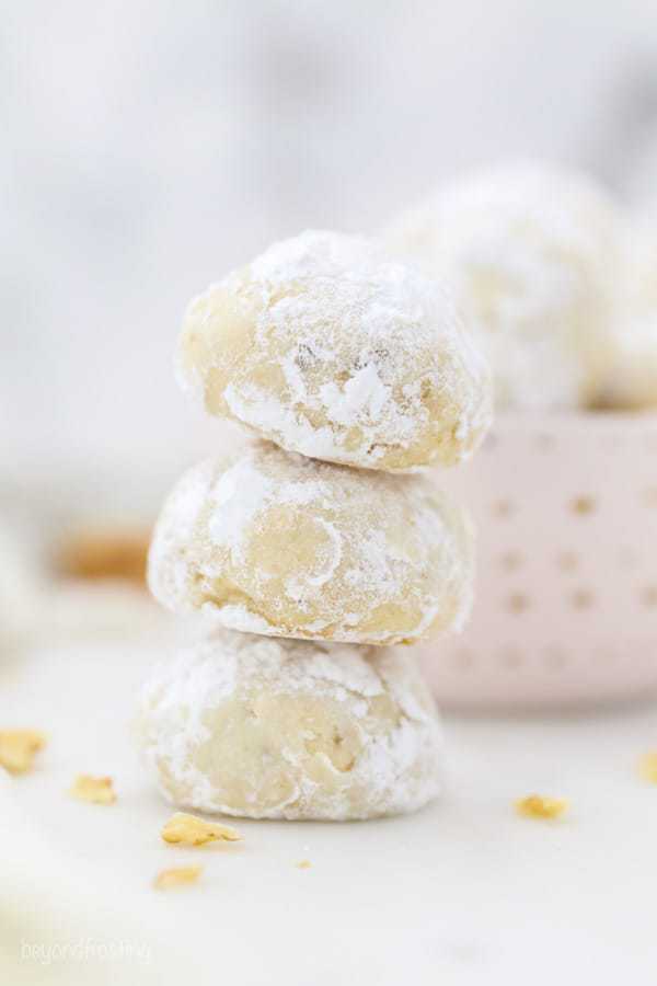 A stack of 3 Snowball Cookies rolled in powdered sugar