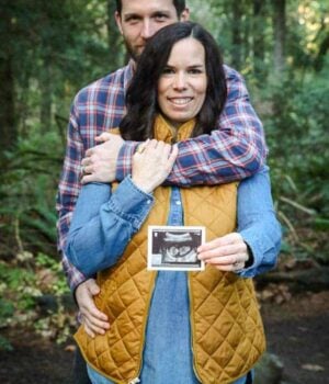 A baby announcement with the husband and wife holding an Ultrasound photo