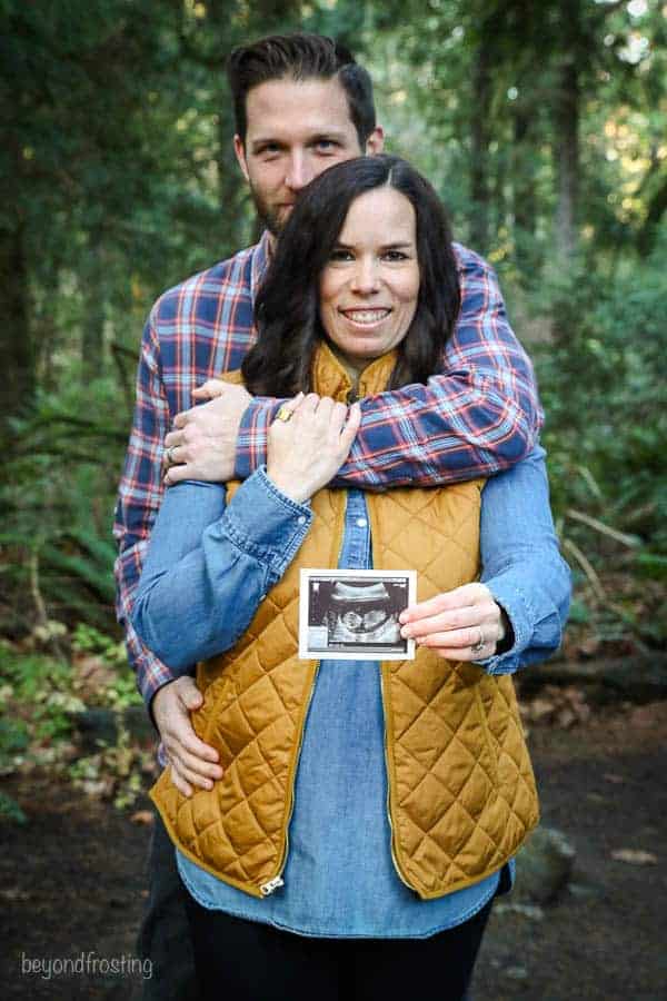 A baby announcement with the husband and wife holding an Ultrasound photo