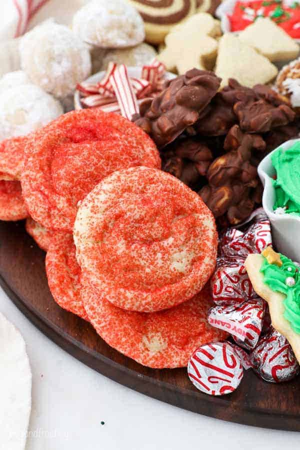 A close up of a dessert charcuterie board showing red sprinkle covered sugar cookies