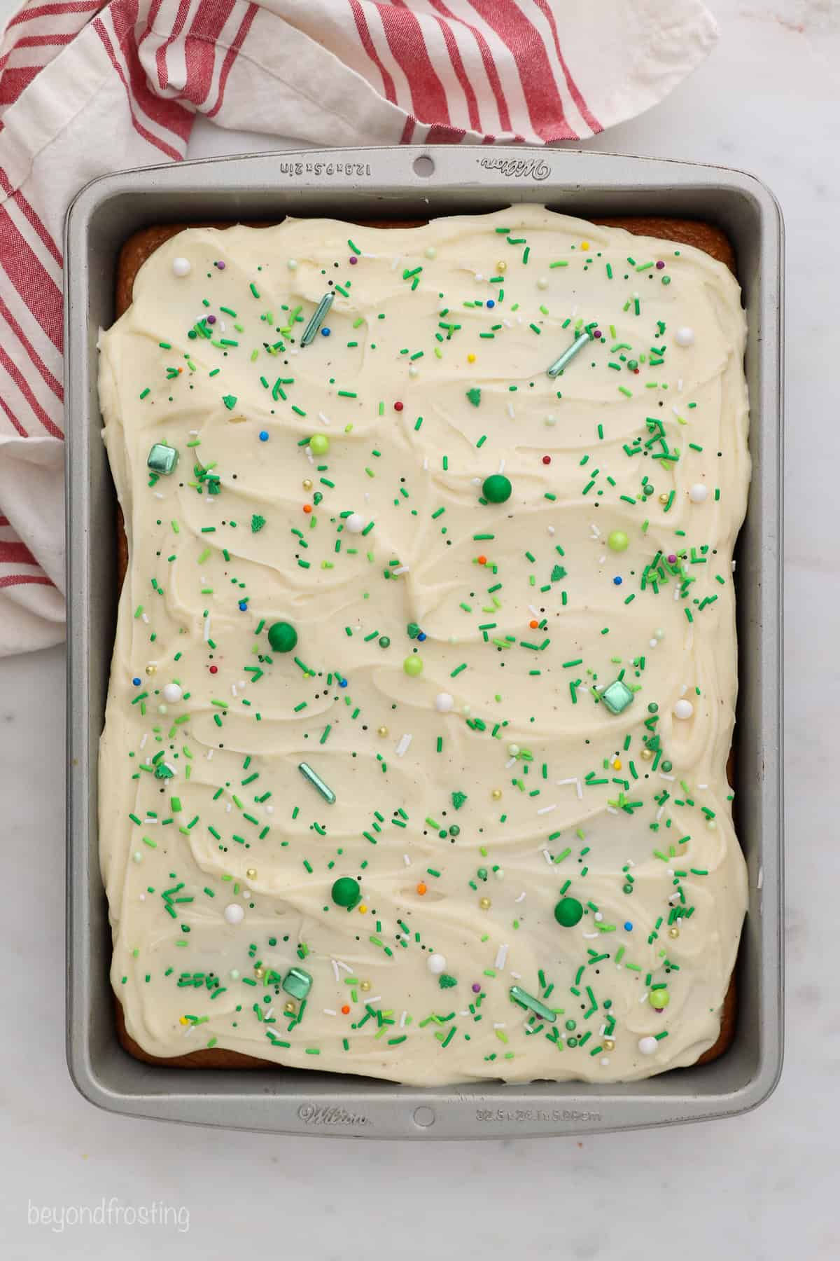 Overhead view of frosted gingerbread cake in a rectangular cake pan.