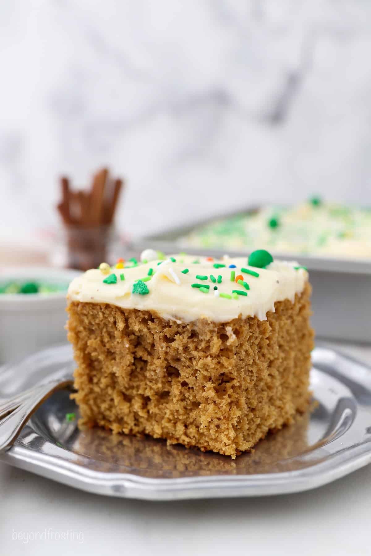 A slice of gingerbread cake on a plate next to a fork.