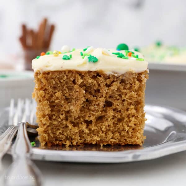 A slice of gingerbread cake on a plate next to a fork.