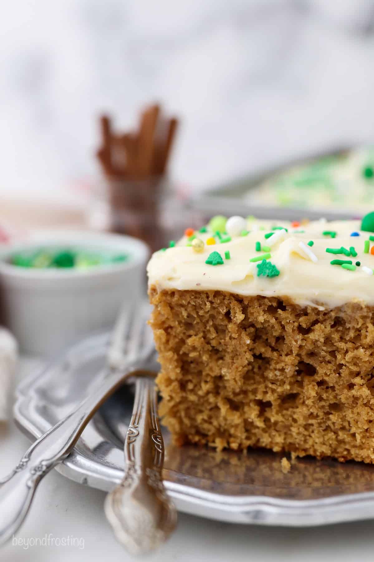 A slice of gingerbread cake on a plate next to a fork.