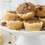 A small white cake stand with mini pecan pies on top