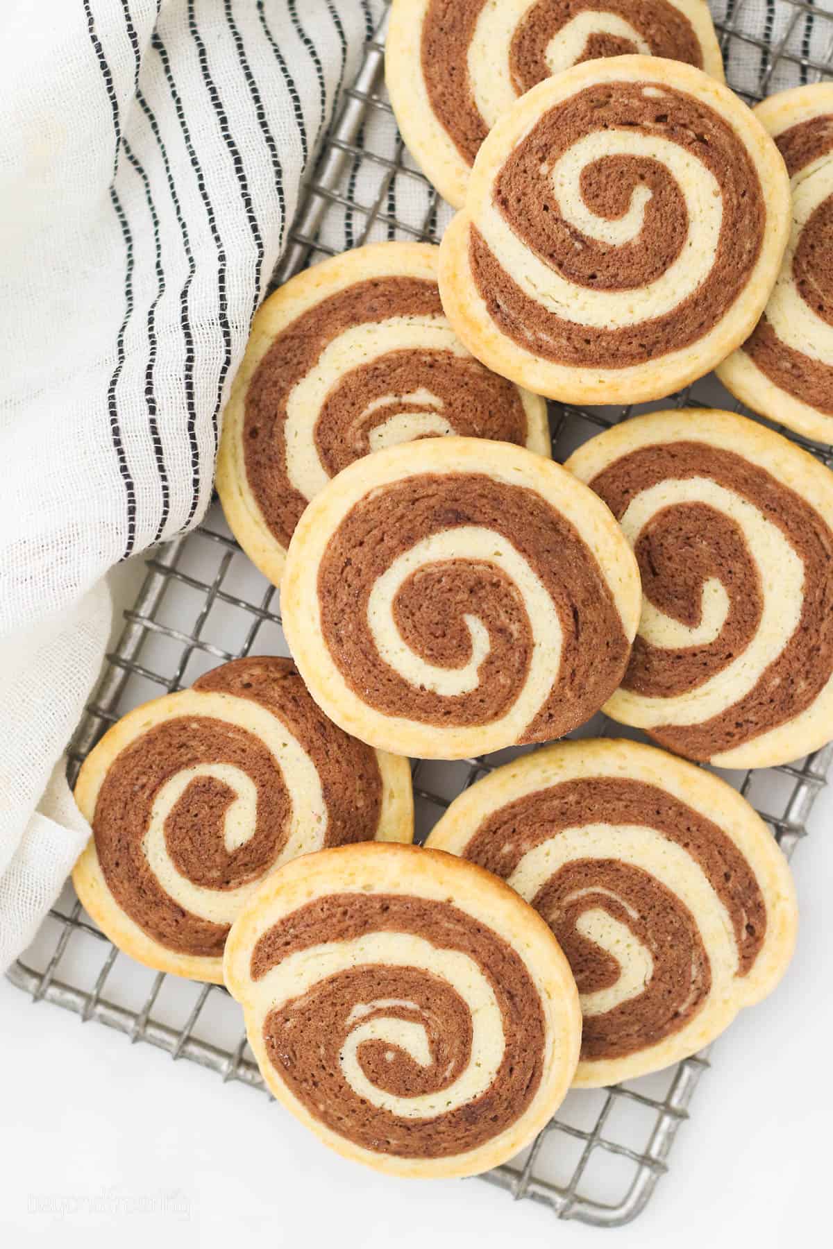 Pinwheel cookies piled on a wire rack.