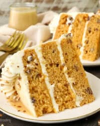 A slice of salted caramel butterscotch cake on a plate with a second slice in the background.