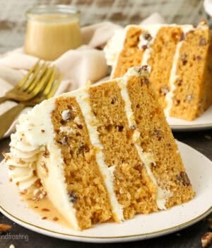 A slice of salted caramel butterscotch cake on a plate with a second slice in the background.