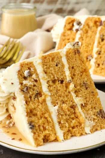 A slice of salted caramel butterscotch cake on a plate with a second slice in the background.