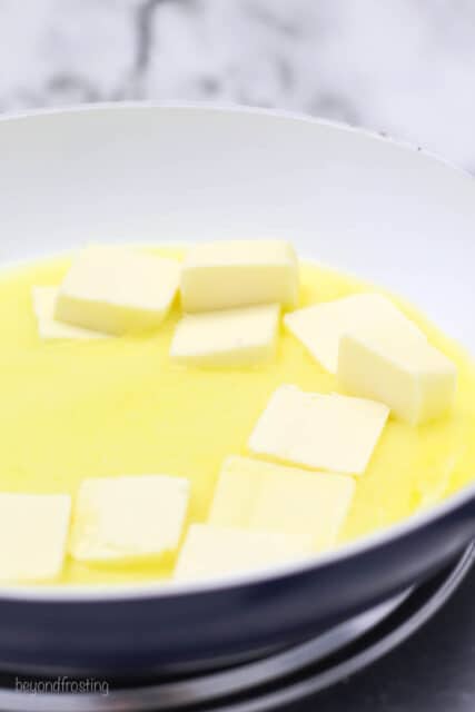 Partially melted cubes of butter in a shallow saucepan.