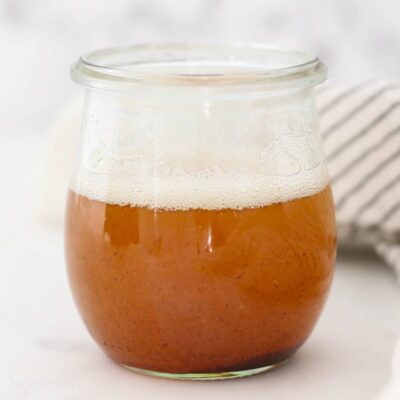 Brown butter in a glass jar on a countertop.