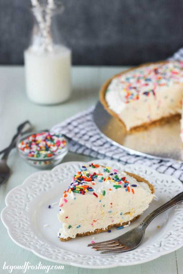 A slice of funfetti ice cream on a white plate with a silver fork