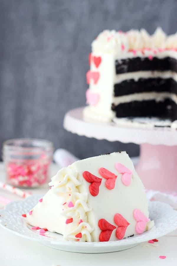 A pretty slice of cake decorated with pink and red buttercream hearts