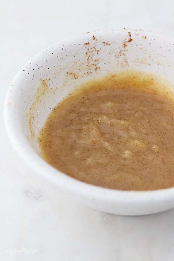 Brown butter that has been melted and stirred in a white bowl