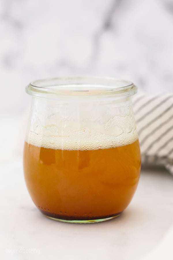 A glass jar filled with a golden brown butter