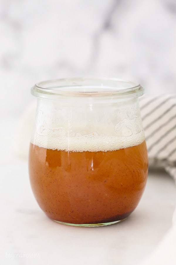 A glass jar filled with a golden brown butter