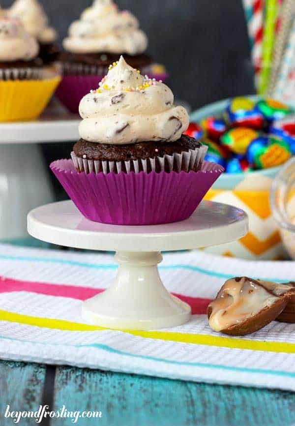 A mini white cupcake stand with a chocolate cupcake on top