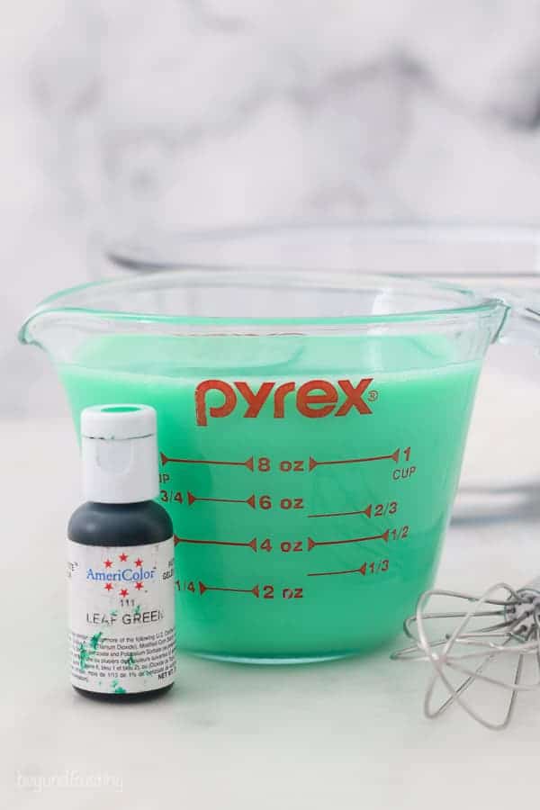 a glass jar filled with milk that has been dyed green