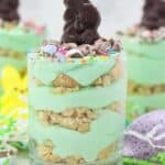 Three jars layered with Oreo and green colored mousse topped with an Easter bunny candy
