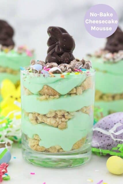 Three jars layered with Oreo and green colored mousse topped with an Easter bunny candy with a text overlay