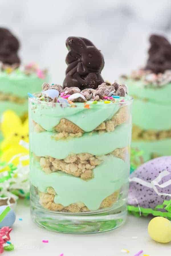 Three jars layered with Oreo and green colored mousse topped with an Easter bunny candy