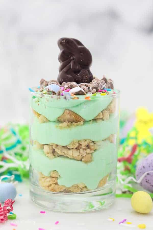 A picture of a jar layered with Oreo and green colored mousse topped with an Easter bunny candy