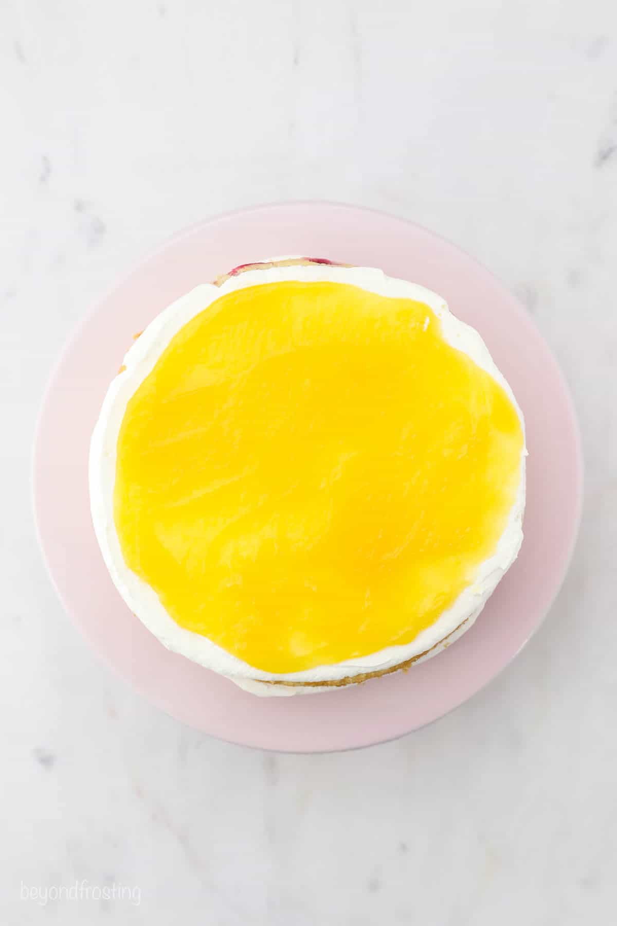 Lemon curd layered on top of mascarpone frosting on a cake