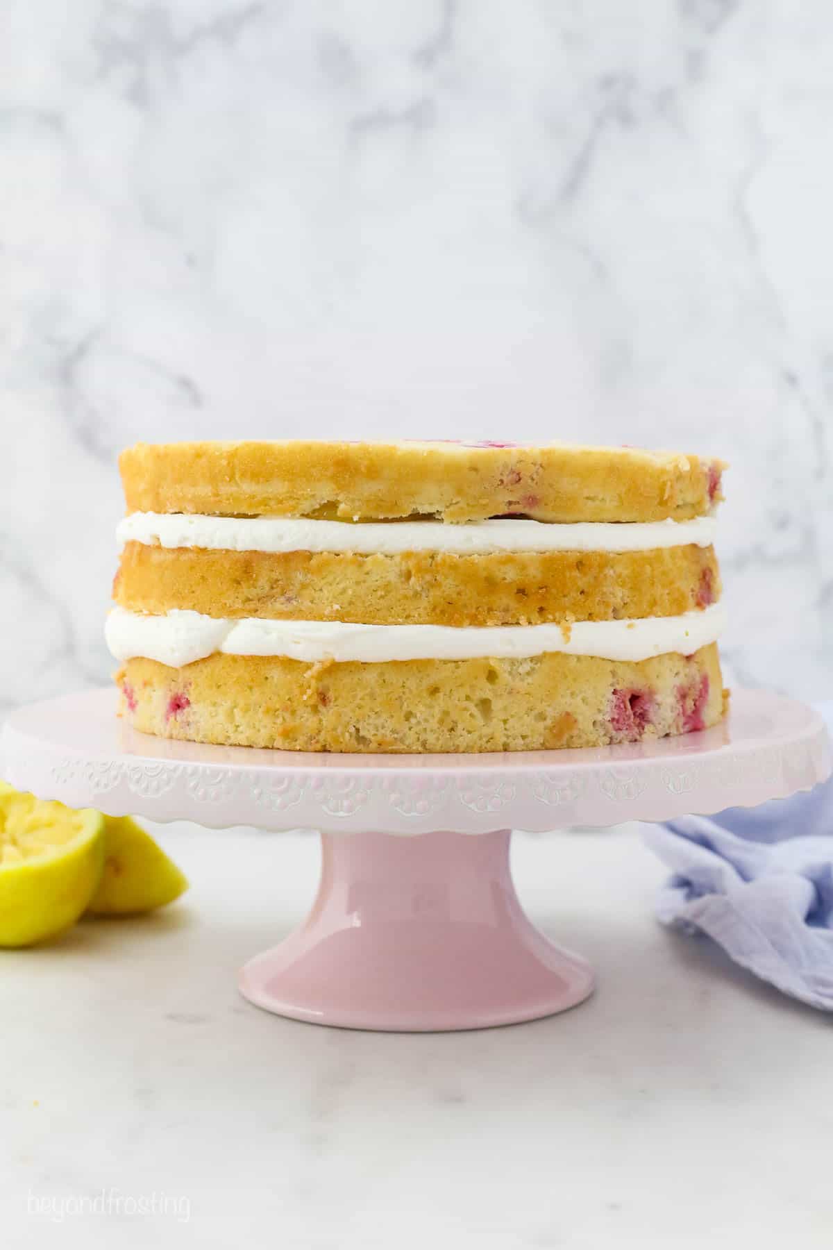 Side view of an unfrosted lemon raspberry layer cake