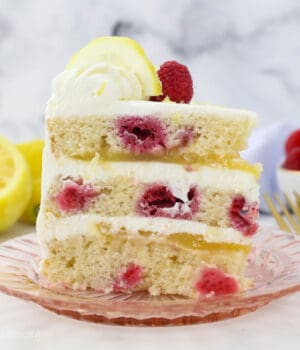 A slice of lemon raspberry cake on a pink plate