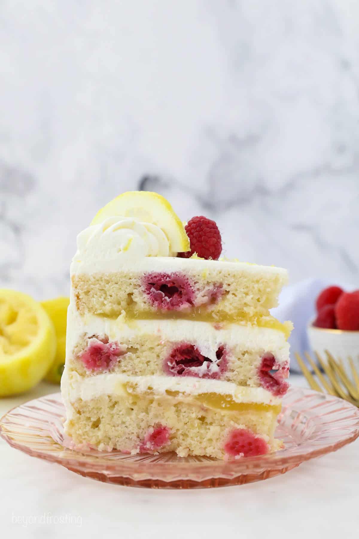 A slice of lemon raspberry layer cake on a plate