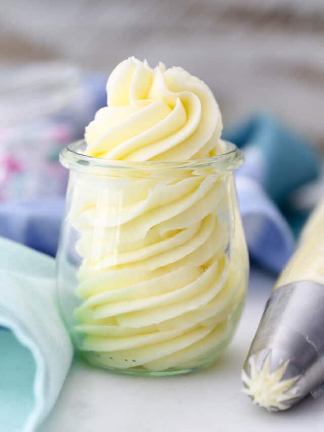 Vanilla buttercream frosting swirled in a glass jar.