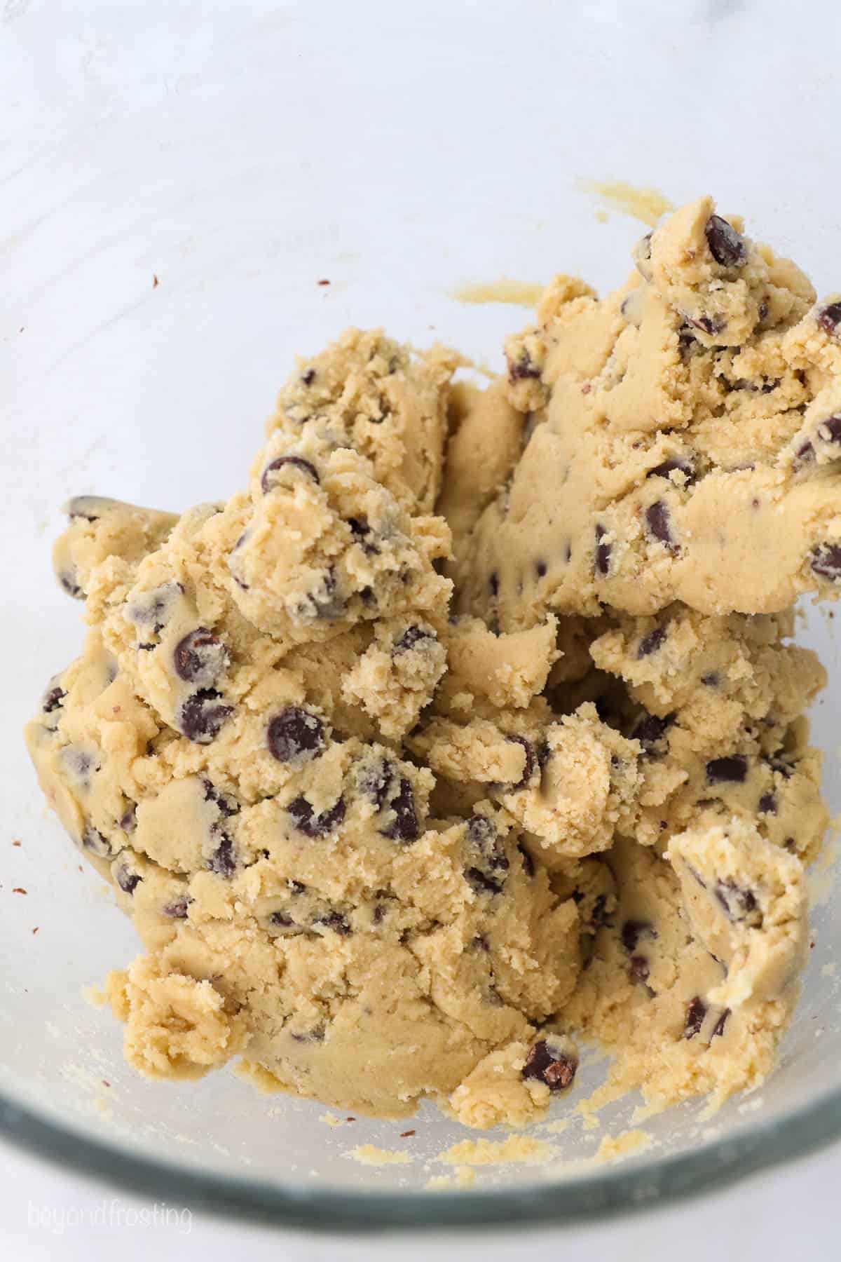 Chocolate chip cookie dough batter in a glass bowl
