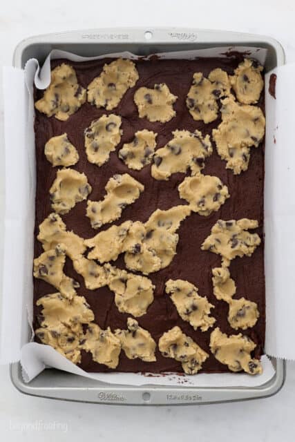 A baking sheet with brownie batter and cookie dough on top