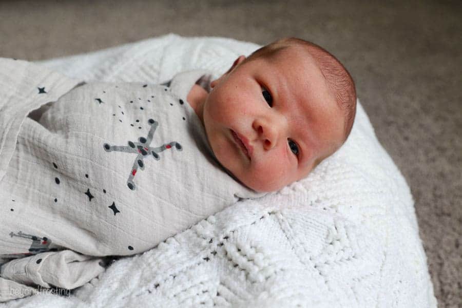 a baby wrapped in a Star Wars Swaddle