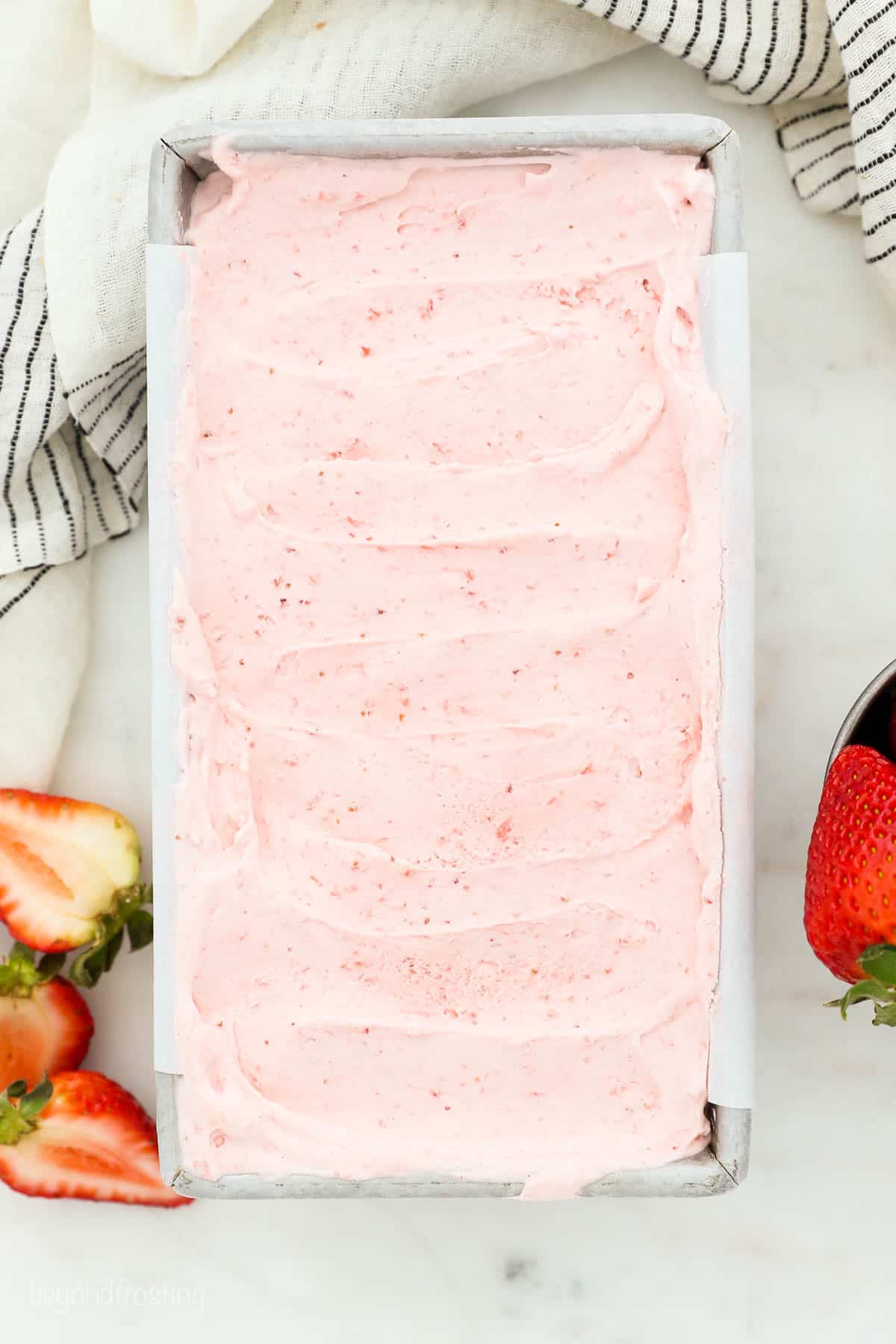 Overhead view of homemade strawberry ice cream in a loaf pan.