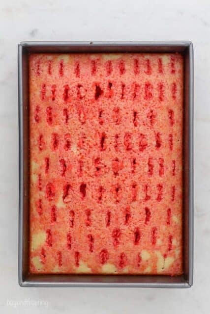 an overhead shot of a vanilla cake drizzled with red jello