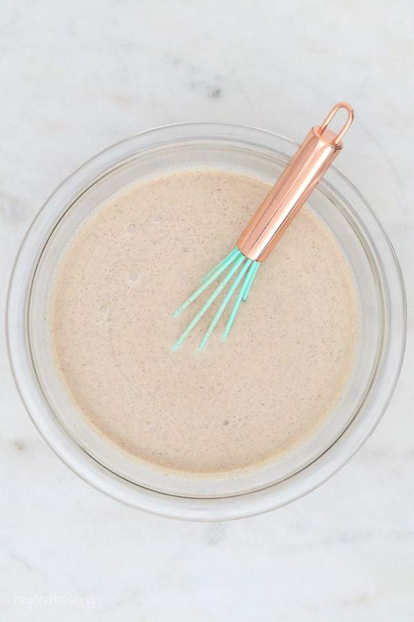 An overhead shot of a cinnamon ice cream mixture with a whisk in it
