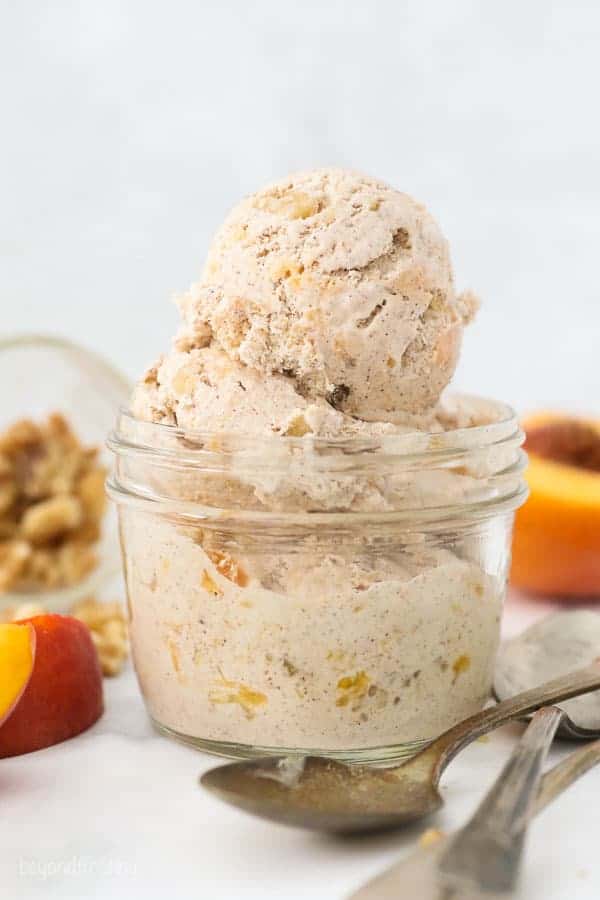 A small mason jar with a couple scoops of peach ice cream