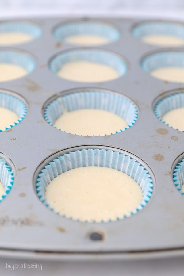 uma forma de cupcake com liners, recheada 2/3 cheia de massa